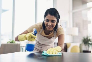 Shot of a young woman disinfecting a table at home